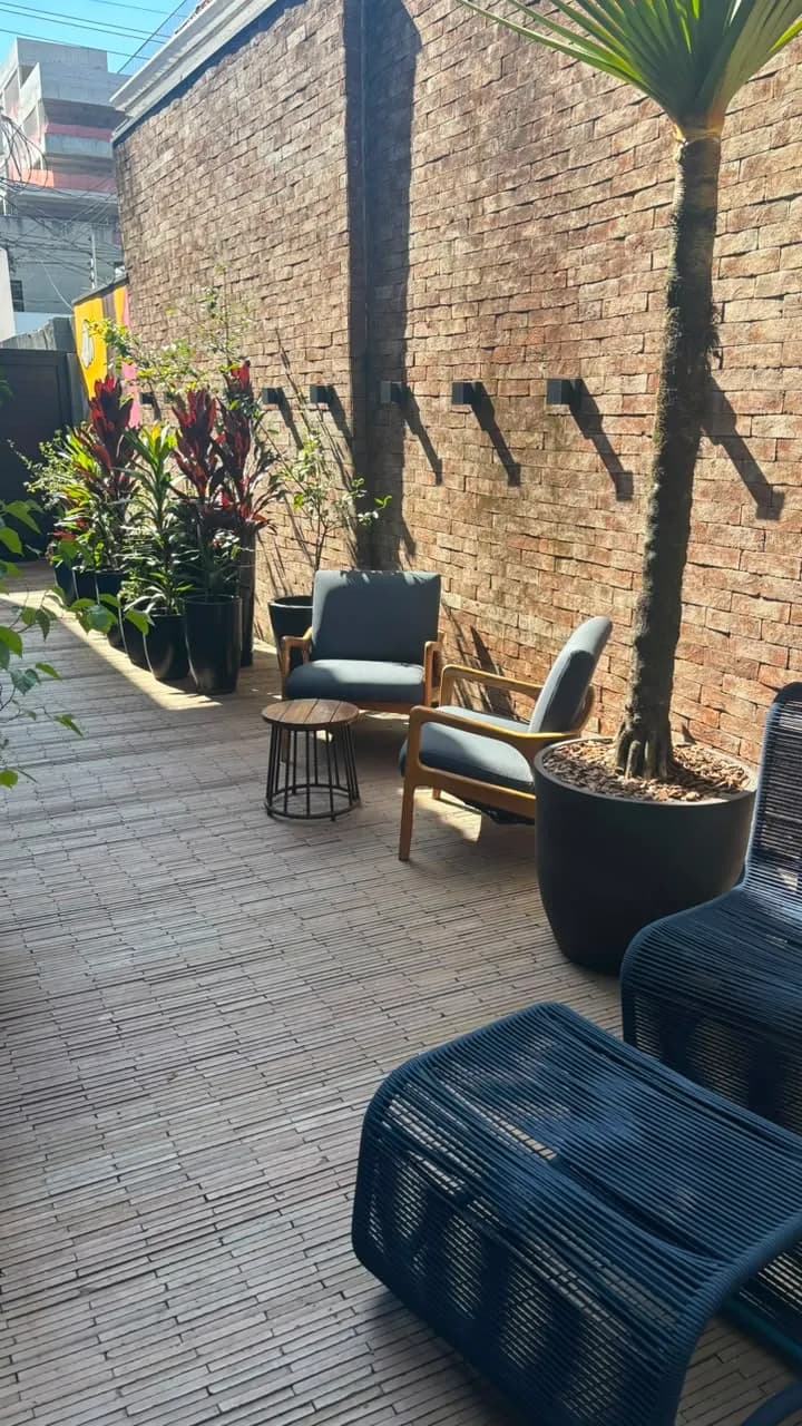 Área externa com plantas e poltronas